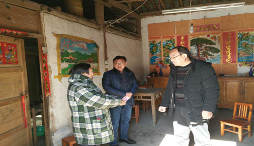 图为新县残联理事长姜振宇（右一）慰问困难残疾人