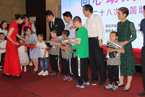 图为 市委副刘国栋向孩子们赠送服装