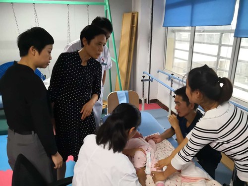 图为 吴蕾理事长在息县人民医院检查残疾儿童康复工作